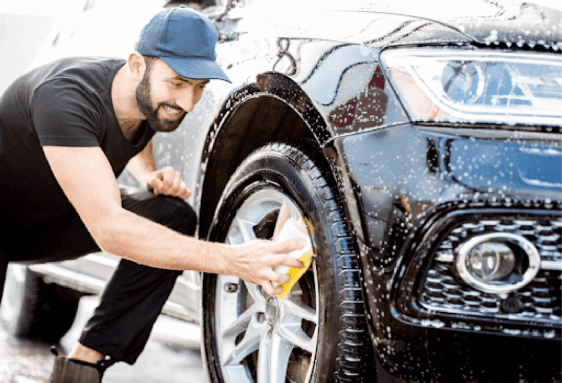 A man is using car cleaning chemicals after purchasing them from a store. 